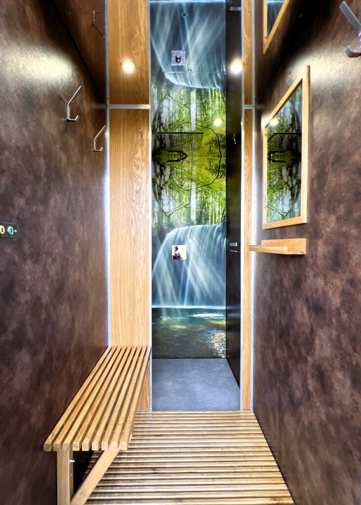 Innenraum des Duschcontainers in Rost-Optik mit Wasserfall
